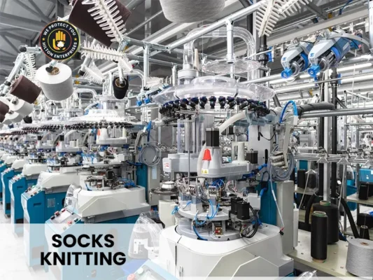 Close-up of circular sock knitting machine showing needle cylinder and yarn feeding system