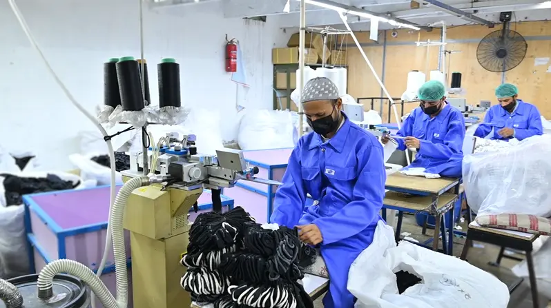 Wide interior view of Hilton Enterprises ISO-certified socks manufacturing facility in Faisalabad Pakistan showing knitting machines and production workers