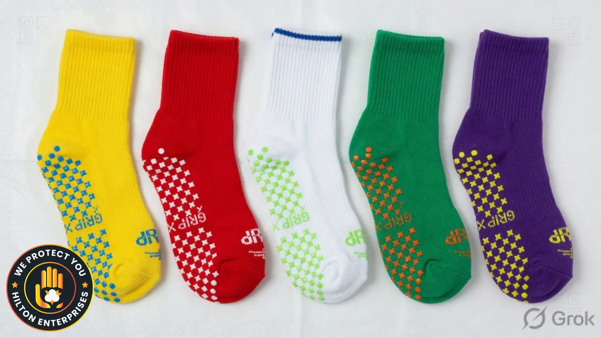 Five colour-coded hospital grip socks in a row — yellow, red, white, green, purple — with non-slip rubber dot patterns visible on soles